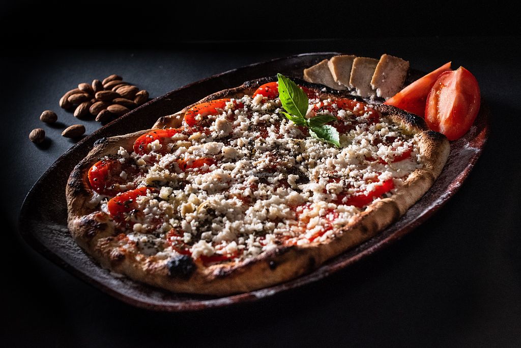 Primavera Peronista: Our version of the classic spring pizza, with slices of fresh tomatoes, basil leaves and homemade almond parmesan. Pizza primavera, queso de almendras homemade
